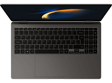 Charger l&#39;image dans la galerie, Un ordinateur portable avec écran ouvert, montrant un clavier et un pavé tactile, sur une surface grise.
