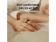 Charger l&#39;image dans la galerie, La main d&#39;une personne portant une bague intelligente noire sur un lit.
