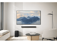 Charger l&#39;image dans la galerie, Une TV montrant des montagnes, une barre de son en dessous, un caisson de basses en dessous, et une pièce moderne.
