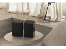 Charger l&#39;image dans la galerie, Deux enceintes noires sur une table blanche, avec un vase et une fenêtre en arrière-plan.
