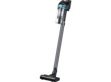Charger l'image dans la galerie, Un aspirateur sans fil Samsung noir et bleu. Il est incliné, montrant la poignée et la tête de brosse.
