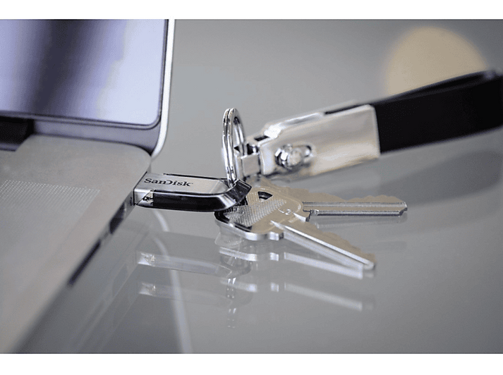 Clé USB, clés et porte-clés à côté d'un ordinateur portable.