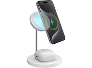 Support de charge sans fil avec téléphone et écouteurs. Le téléphone est en charge. Base blanche.