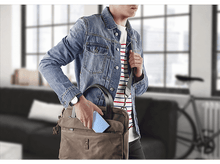 Charger l&#39;image dans la galerie, Un homme en veste en jean sort un appareil bleu d&#39;un sac marron. Arrière-plan flou.
