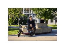 Charger l&#39;image dans la galerie, Homme blond assis sur un banc avec une trottinette électrique.
