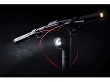 Charger l&#39;image dans la galerie, Guidon de scooter avec lumières et câble rouge, sur fond sombre.
