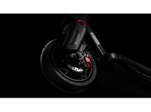 Charger l&#39;image dans la galerie, Gros plan sur la roue avant d&#39;une trottinette électrique, avec un pneu noir et un disque de frein rouge.
