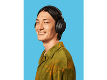 Charger l&#39;image dans la galerie, Un homme portant un casque sourit. Fond bleu. Chemise verte.
