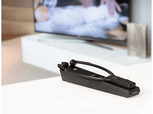 Charger l&#39;image dans la galerie, Un appareil auditif noir avec un microphone sur une surface blanche.
