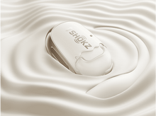 Charger l&#39;image dans la galerie, Écouteur dans un liquide crémeux. Immergé dans un liquide blanc crémeux, fond blanc.
