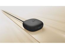 Charger l&#39;image dans la galerie, Étui de chargement Shokz noir avec un câble, sur une surface en bois.
