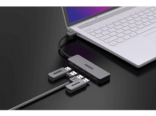 Charger l&#39;image dans la galerie, Un ordinateur portable connecté à un hub gris avec des ports USB. Plusieurs adaptateurs USB sont connectés.
