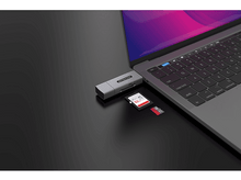 Charger l&#39;image dans la galerie, Un ordinateur portable connecté à un adaptateur argenté avec USB et une carte SD.
