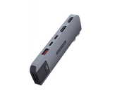 Un appareil gris avec des ports est incliné en diagonale. L'appareil dispose de ports HDMI, USB et autres. Il est sur un fond blanc et noir.