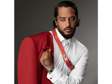 Charger l&#39;image dans la galerie, Un homme en chemise blanche et veste rouge, regardant de côté, avec un tatouage sur la main.
