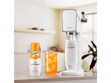 Charger l&#39;image dans la galerie, Une machine SodaStream blanche, une bouteille d&#39;arôme orange et un verre de soda à l&#39;orange avec de la glace.
