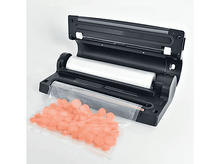 Charger l&#39;image dans la galerie, Une scelleuse sous vide noire avec un rouleau de plastique et un sac de carottes tranchées.
