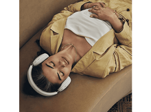 Charger l&#39;image dans la galerie, Une femme est allongée sur un canapé, portant un casque, une chemise blanche et une veste jaune.
