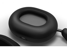 Charger l&#39;image dans la galerie, Gros plan sur un casque noir avec un coussinet rembourré. L&#39;accent est mis sur le matériau souple et la forme du coussinet.
