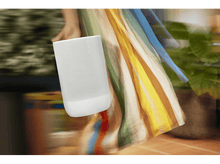 Charger l&#39;image dans la galerie, Une personne en robe fluide tient une enceinte Sonos blanche, mouvement flou.
