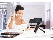 Charger l&#39;image dans la galerie, Une femme enregistre un tutoriel de maquillage, appliquant du fard à joues.
