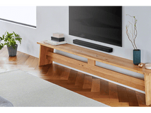 Charger l&#39;image dans la galerie, Aménagement de salon avec une télévision sur un banc en bois, une barre de son et une plante.
