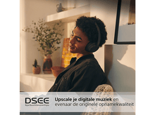 Charger l&#39;image dans la galerie, Femme portant un casque, yeux fermés, dans une pièce avec plante et fenêtre.
