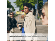 Charger l&#39;image dans la galerie, Homme avec casque et manteau, tasse à café, dans la rue.
