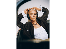 Charger l&#39;image dans la galerie, Femme blonde portant un casque et un blazer marron. Elle est dans une voiture, regardant ailleurs.
