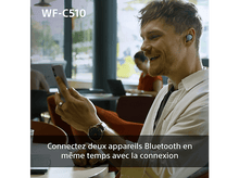 Charger l&#39;image dans la galerie, L&#39;homme utilise un téléphone, portant des écouteurs. Connectez deux appareils Bluetooth simultanément.
