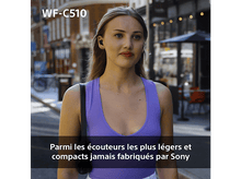 Charger l'image dans la galerie, Une femme portant des écouteurs se tient dans une rue. Texte en bas de l'image.
