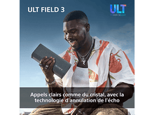 Charger l&#39;image dans la galerie, Un homme sourit, tenant un haut-parleur gris. Il porte une chemise colorée, des bijoux. Le ciel est bleu, et le haut-parleur a le logo Sony.
