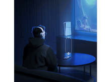 Charger l&#39;image dans la galerie, Une personne avec un casque regarde une télévision et un téléphone avec une icône sans fil est affichée.
