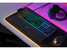 Charger l&#39;image dans la galerie, Configuration de jeu : clavier éclairé, souris et tapis sur un bureau blanc. Casque aussi.
