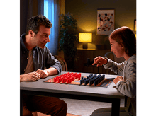 Charger l&#39;image dans la galerie, Père et fille jouant à un jeu de société. Pièces rouges et bleues sur un plateau.
