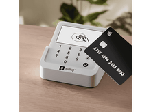 Charger l&#39;image dans la galerie, Une carte de crédit noire au-dessus d&#39;un terminal de paiement blanc.
