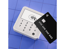 Charger l&#39;image dans la galerie, Un terminal de paiement blanc et une carte de crédit noire sur une surface carrelée bleue.
