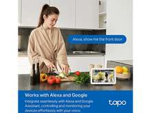 Charger l&#39;image dans la galerie, Femme coupant des légumes sur un comptoir. Une tablette montre la vue de la porte d&#39;entrée.
