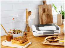 Charger l&#39;image dans la galerie, Un comptoir de cuisine avec des gaufres, un sandwich et d&#39;autres ustensiles de cuisine.
