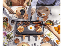 Charger l&#39;image dans la galerie, Des gens grillent de la nourriture sur un grill raclette. Comprend des crêpes, des œufs, du bacon et des saucisses.
