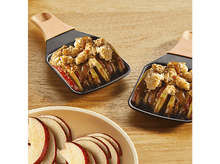 Charger l&#39;image dans la galerie, Deux crumbles aux pommes dans de petites poêles et des pommes tranchées.
