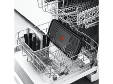 Charger l&#39;image dans la galerie, Un lave-vaisselle avec une poêle antiadhésive noire et des ustensiles noirs dans un panier, le tout sur fond blanc.
