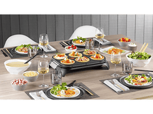 Charger l&#39;image dans la galerie, Table à manger avec nourriture, boissons et un grill à raclette au centre.
