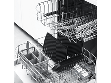 Charger l&#39;image dans la galerie, Un lave-vaisselle avec deux paniers. Des plaques de cuisson noires et un panier sont dans les paniers. La porte est ouverte.
