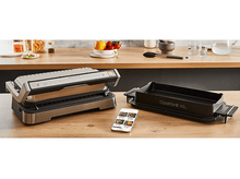 Charger l&#39;image dans la galerie, Un appareil de cuisson avec un plateau noir et un smartphone sur la table.
