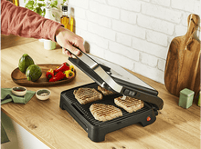 Charger l&#39;image dans la galerie, Une personne fait griller des steaks avec un grill noir sur une surface en bois, avec des légumes à côté.
