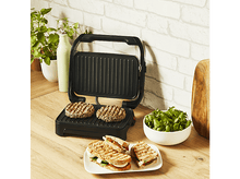 Charger l&#39;image dans la galerie, Burgers et sandwichs grillés sur un grill et une assiette, avec de la salade à proximité.
