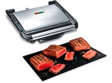 Charger l&#39;image dans la galerie, Gril Tefal avec des steaks cuits sur une planche noire. Steaks grillés avec marques et assaisonnements.
