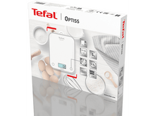 Charger l'image dans la galerie, Une balance de cuisine blanche avec une tasse, un fouet et des œufs est sur une surface blanche.
