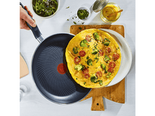 Charger l&#39;image dans la galerie, Omelette sur planche de bois avec ingrédients. Main tient poêle avec omelette. Vue aérienne.
